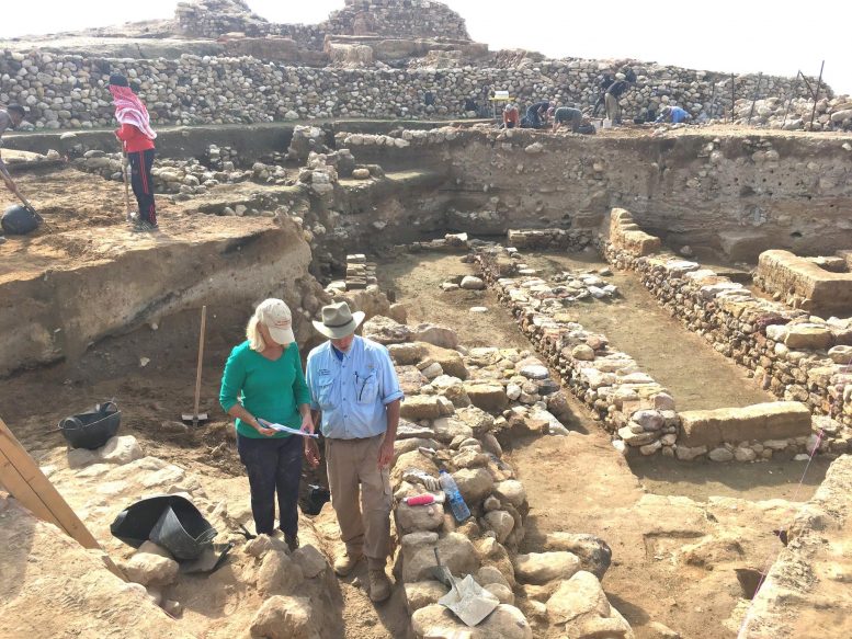 Des chercheurs se tiennent près des ruines d'anciens murs