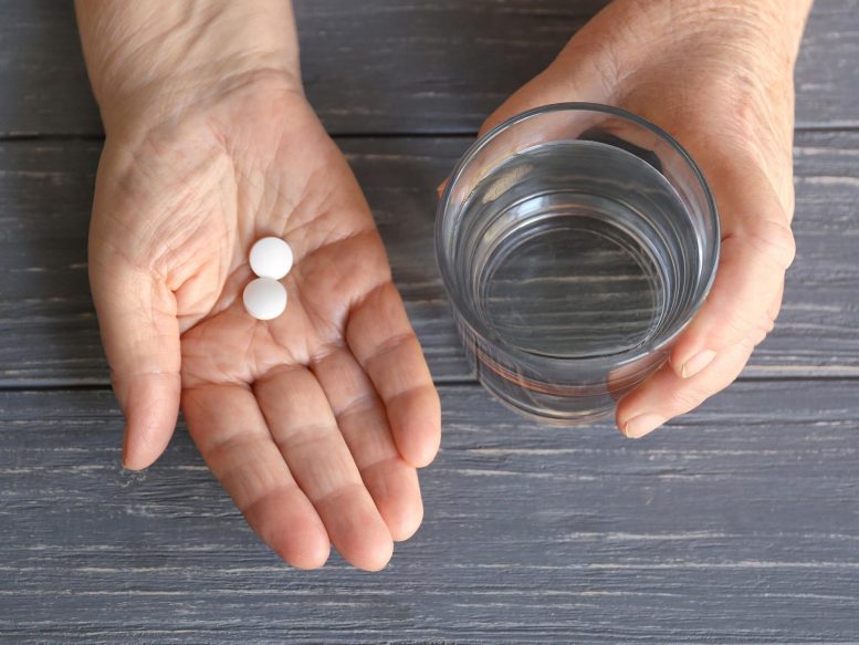Pilules blanches et verre d'eau