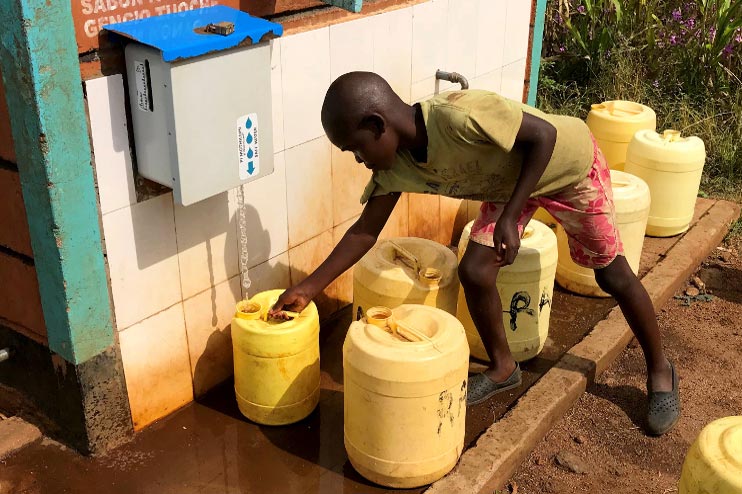 Un enfant récupère de l'eau traitée au chlore dans un kiosque rural au Kenya.