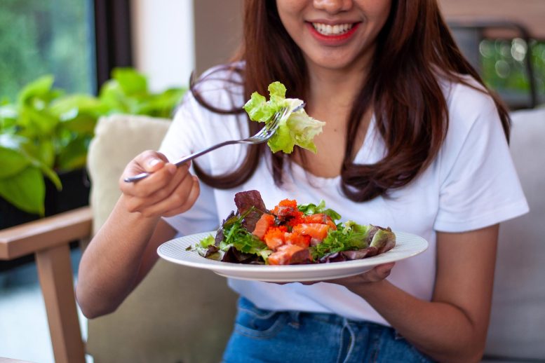 Jeune femme mangeant une salade
