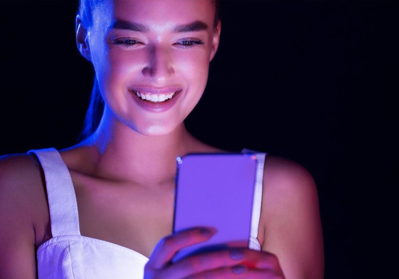 Jeune femme brillant avec un Smartphone