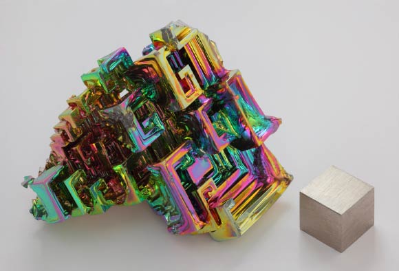 Cristal de bismuth cultivé artificiellement illustrant la structure en escalier, avec un cube de 1 cm3 de bismuth métallique. Crédit image : Heinrich Pniok / CC BY-NC-ND 3.0.