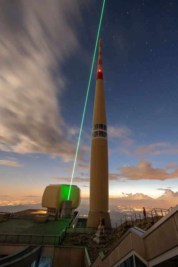 La tour de télécommunication de 124 m de haut du Säntis en Suisse ; on voit également la trajectoire du laser enregistré avec sa seconde harmonique à 515 nm. Crédit image : Houard et al., doi : 10.1038/s41566-022-01139-z.