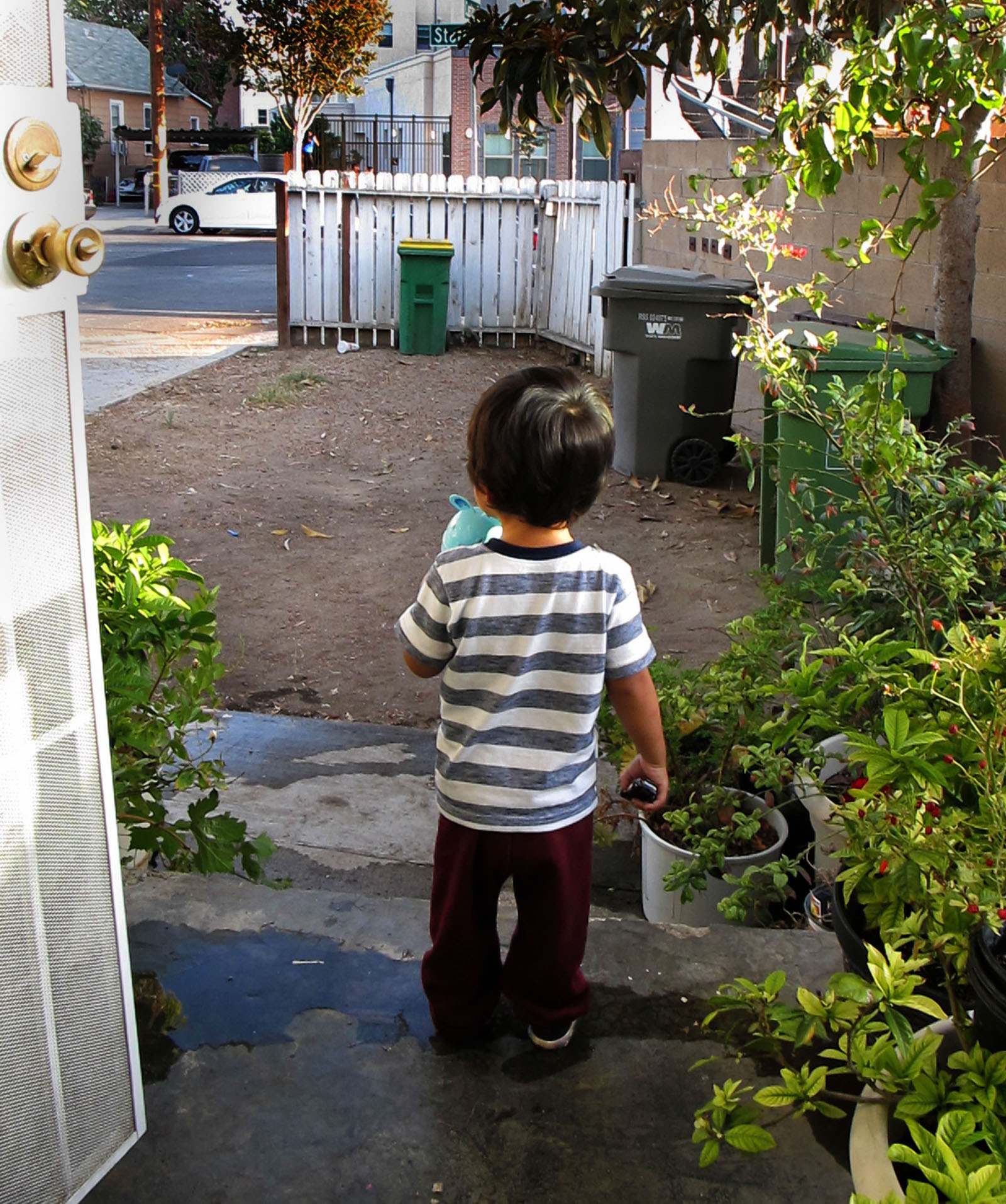 Un jeune garçon regarde une cour avant dans laquelle il joue rarement en raison de la contamination du sol par le plomb