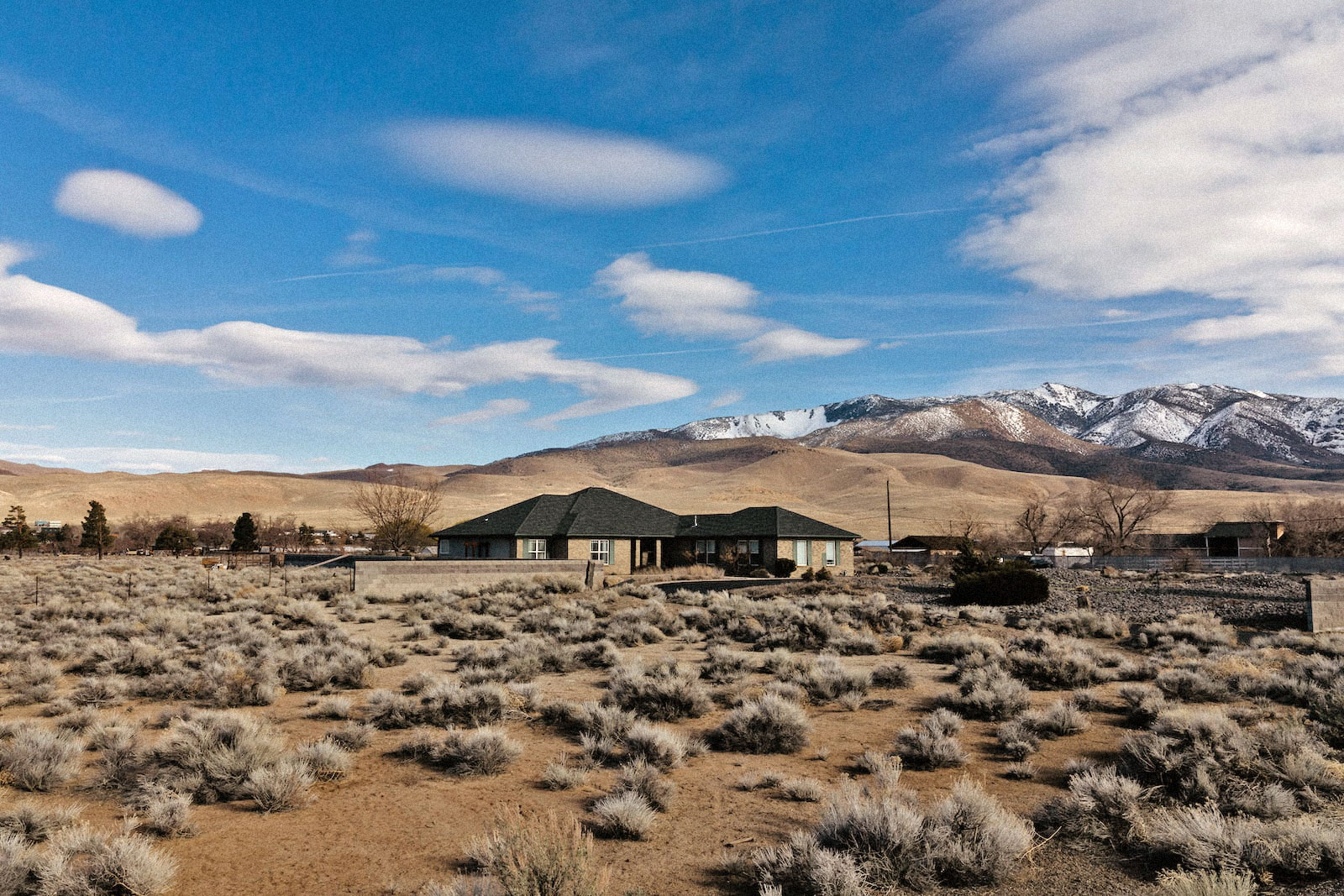 une maison de style ranch au milieu d'un paysage aride