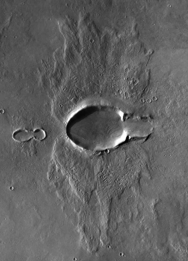 Ce cratère d'impact oblique a une forme étrange d'éjecta de papillon. Il fait 15 kilomètres de long et se trouve au nord d'Acheron Fossae sur Mars. Cette image est une mosaïque de trois images capturées par l'instrument THEMIS sur Mars Odyssey. Crédit d'image : NASA/JPL/UA/mosaïque par Emily Lakdawalla