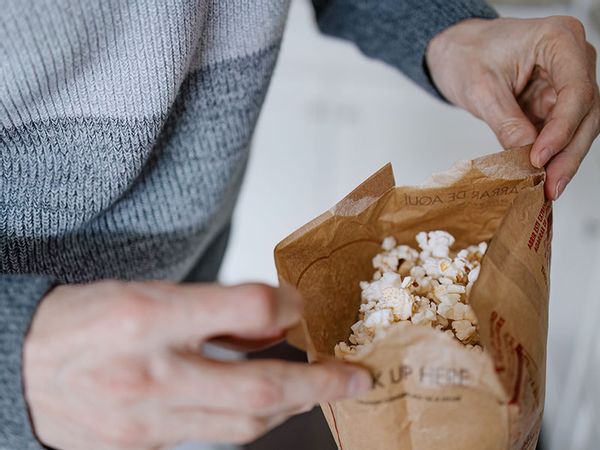 Man Opens a Bag of Microwave Popcorn